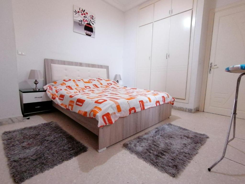 突尼斯My Second Home的一间卧室配有一张床和两块地毯
