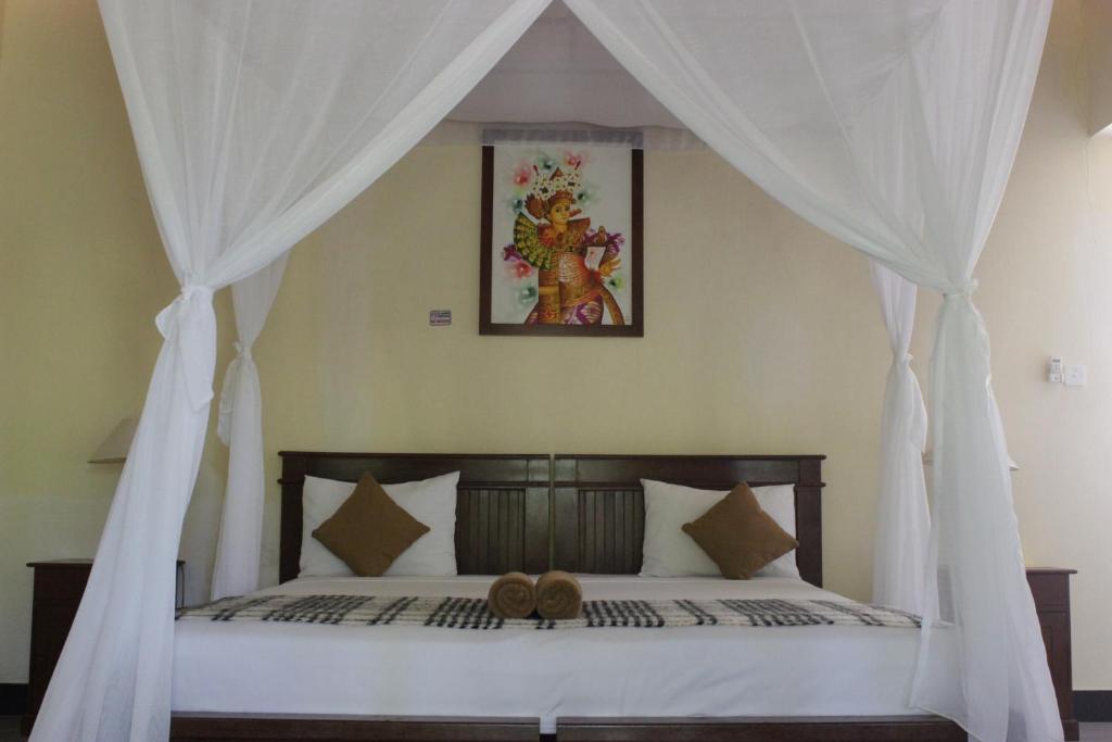 佩母德兰巴厘岛壁虎民宿酒店的一间卧室配有一张带泰迪熊的天蓬床。