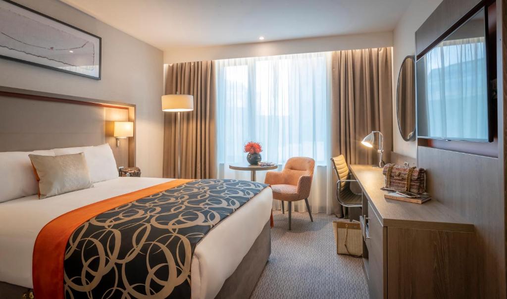 都柏林Clayton Hotel Charlemont的配有一张床和一张书桌的酒店客房