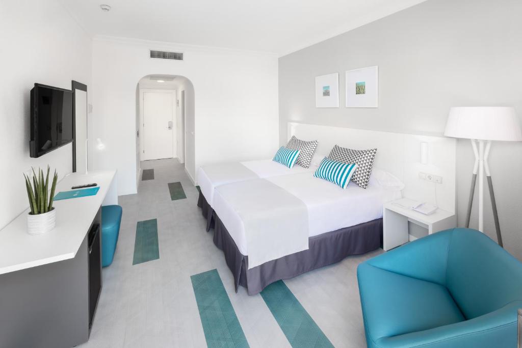 拉克鲁斯Hotel Blue Sea Interpalace的一间卧室配有一张床和一张蓝色椅子
