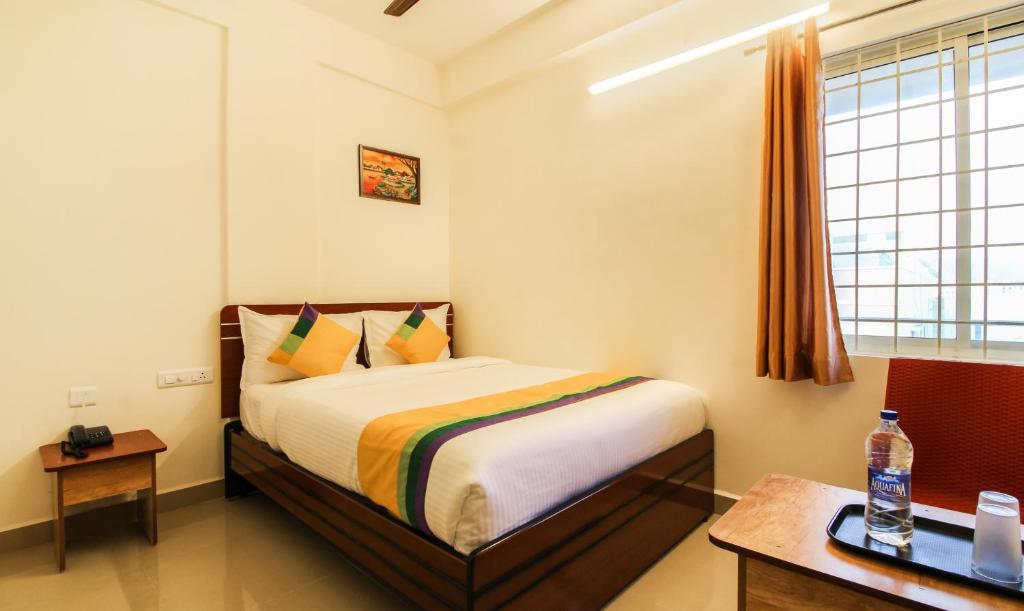 蒂鲁帕蒂Itsy By Treebo - Riyas Grand的一间卧室配有一张床、一张书桌和一个窗户。