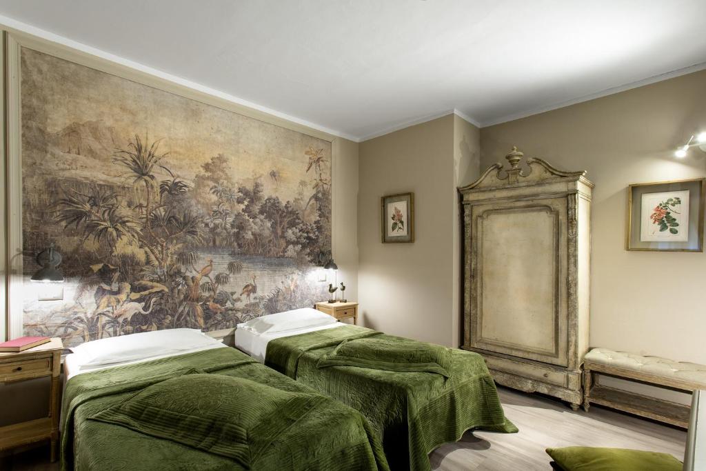 博洛尼亚博尔戈酒店的墙上画画的房间里设有两张床