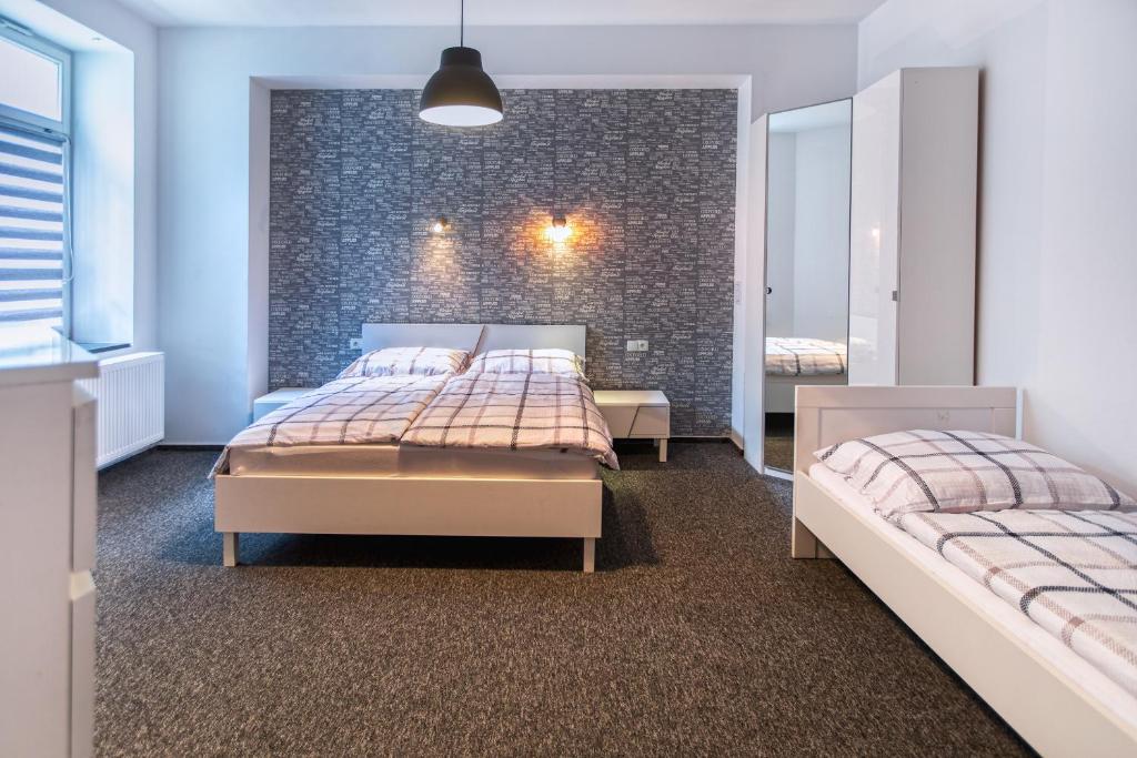 卡托维兹Apartamenty Jana的一间卧室设有两张床和砖墙