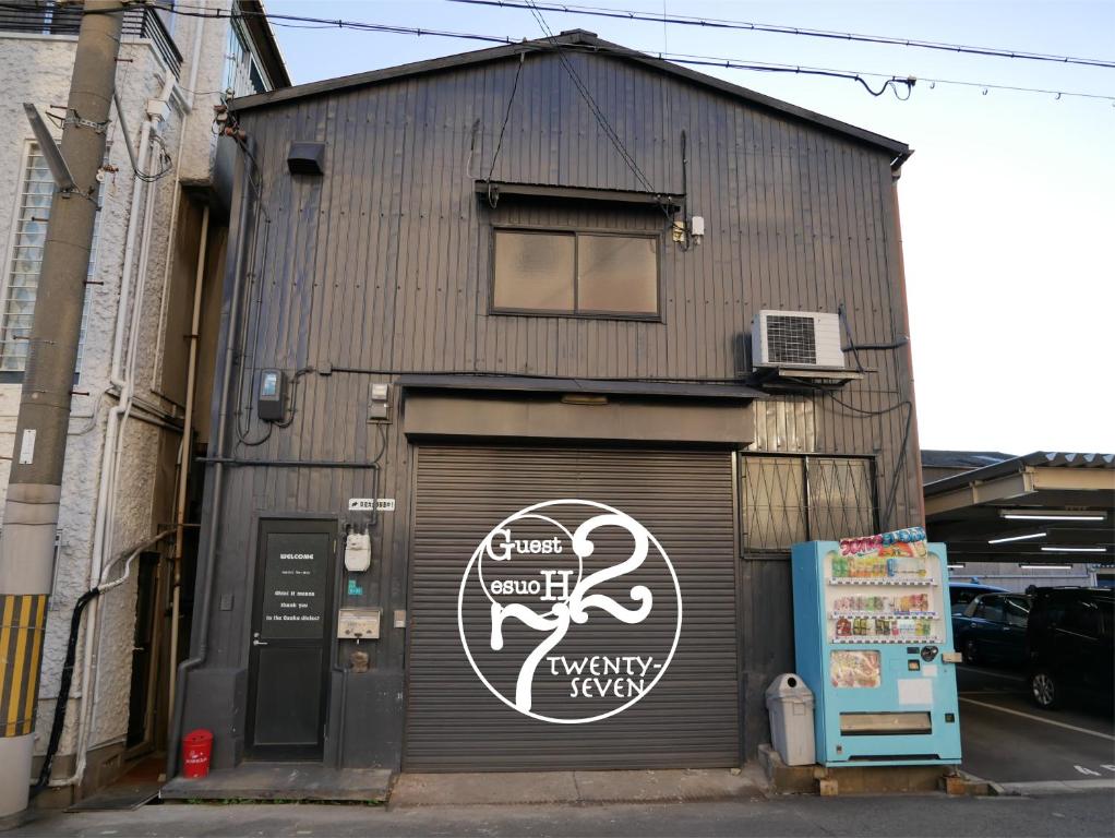 大阪Guest House Twenty-Seven 27的一座带车库门的建筑,上面有标志