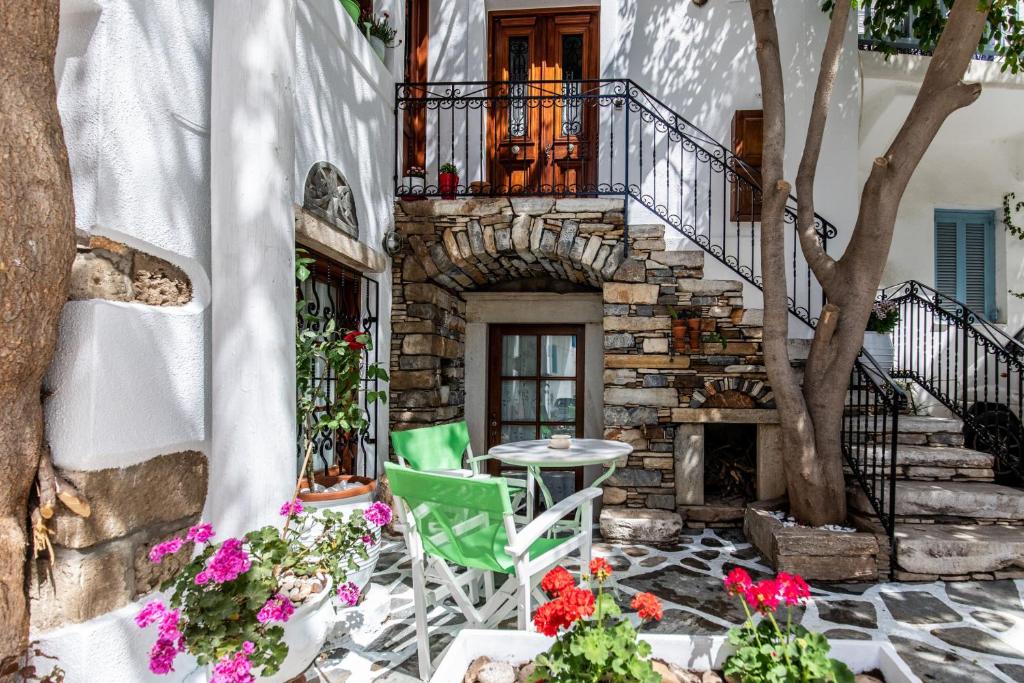 纳克索乔拉Arco Naxos Luxury Apartments的庭院配有桌椅和鲜花