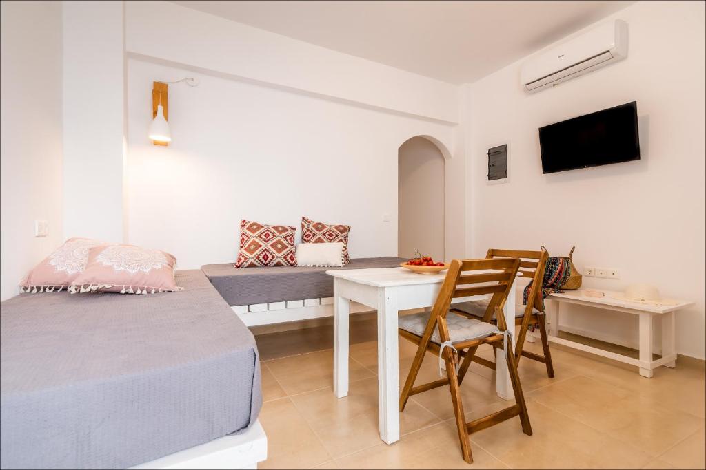 普拉卡米洛斯Krystalia's Apartment的配有一张床和一张桌子及椅子的房间
