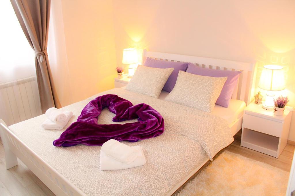 普利特维采湖Sweet Dreams的一张白色的床,上面有紫色的毯子