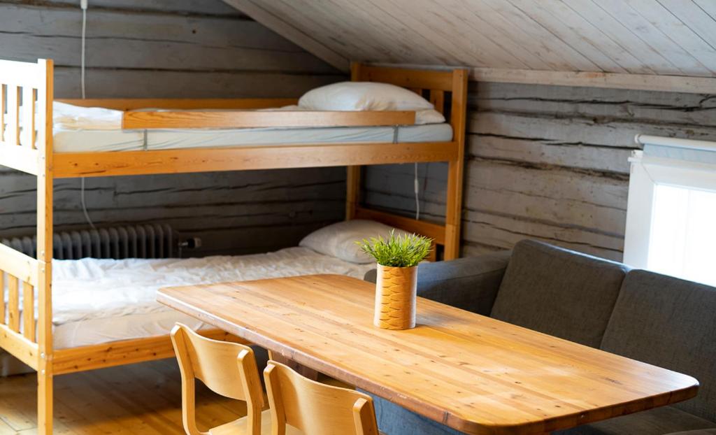 SaxnäsMarsfjäll Mountain Lodge Vandrarhem的客房设有桌子和双层床。