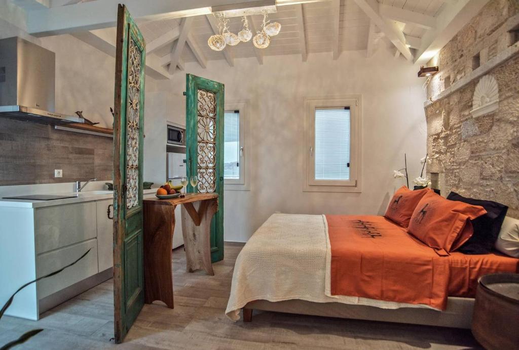库卡里Eftopia Beachfront Studio的一间卧室配有一张带橙色毯子的床和一间厨房