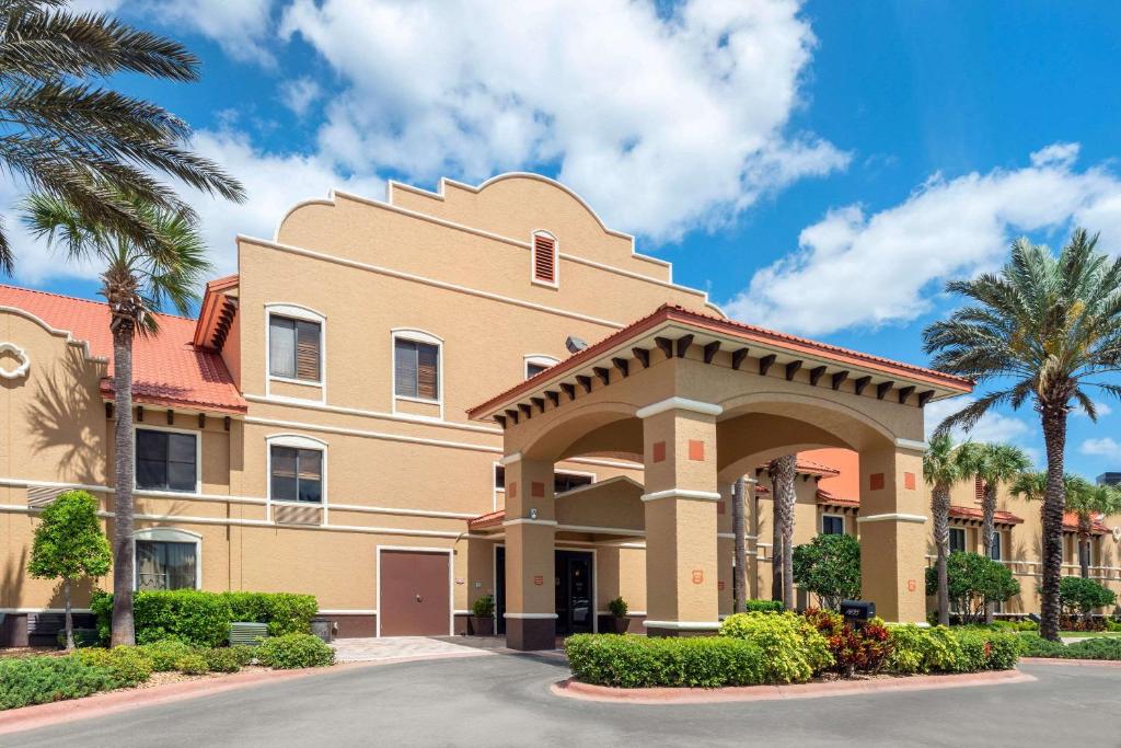 奥蒙德海滩Clarion Inn Ormond Beach at Destination Daytona的棕榈树别墅和建筑