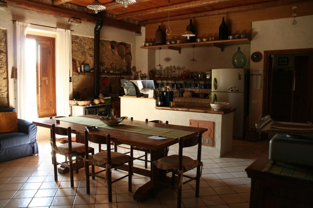 托尔基亚拉罗萨卡尼雅住宿加早餐旅馆的厨房配有桌椅和冰箱。
