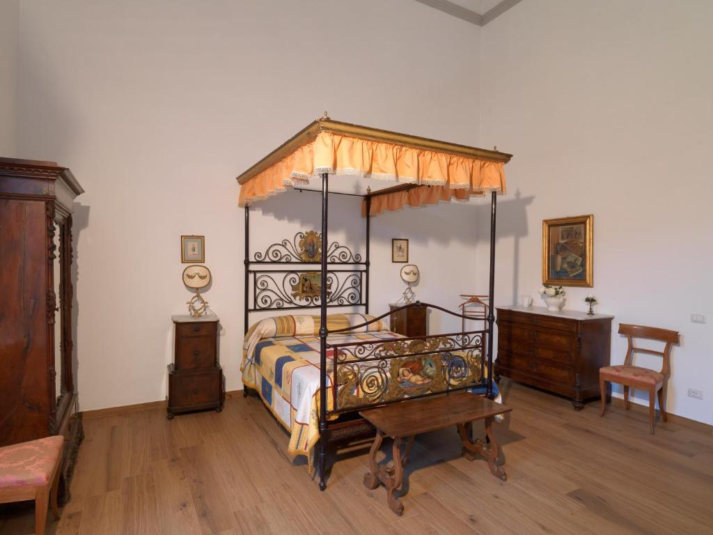 佛罗伦萨Giardino D'Azeglio Locazione Turistica的一间卧室设有一张天蓬床和木地板。