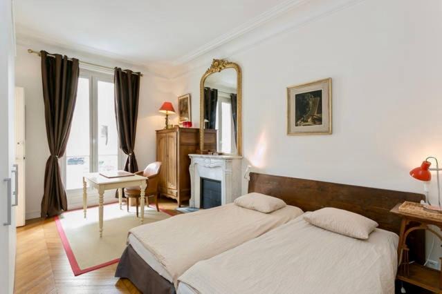 巴黎Charming bedroom的一间卧室配有一张床、一张书桌和一面镜子