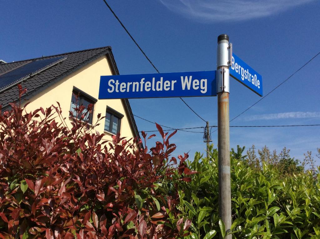 OsburgFerienwohnung Sternfeld的房屋前一条街道标志,供人们走上更星空的道路