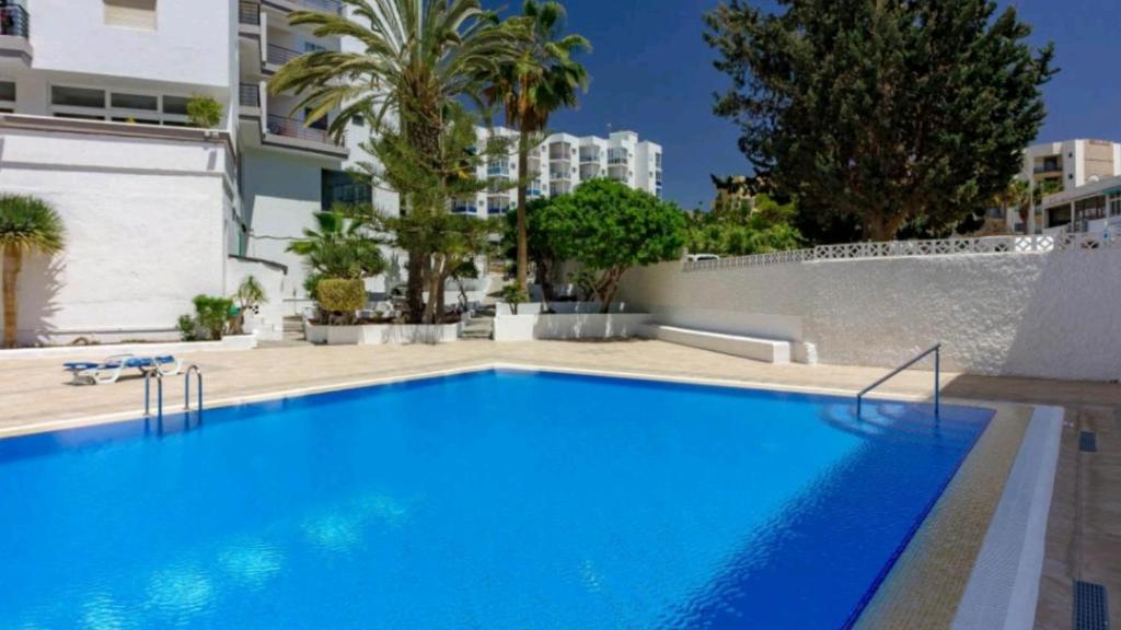 阿罗纳Apartamento con Vistas al Mar en Los Cristianos的一座大型蓝色游泳池,位于大楼旁边