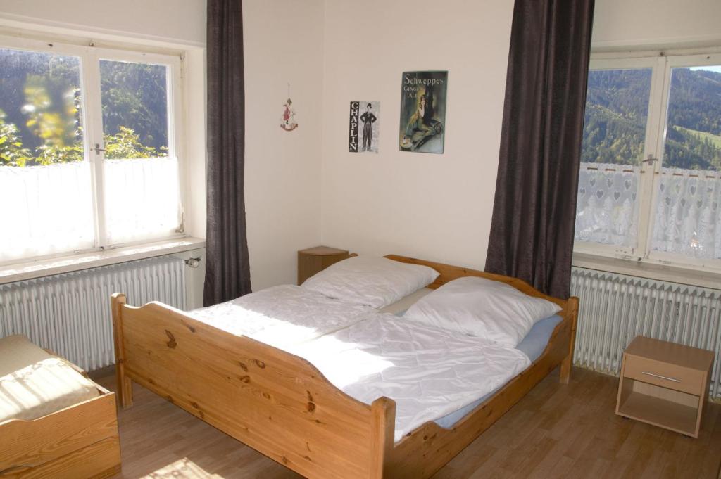 拉特恩斯Berg & Skihütte -Schmittenhof的一间卧室配有木床和2个窗户