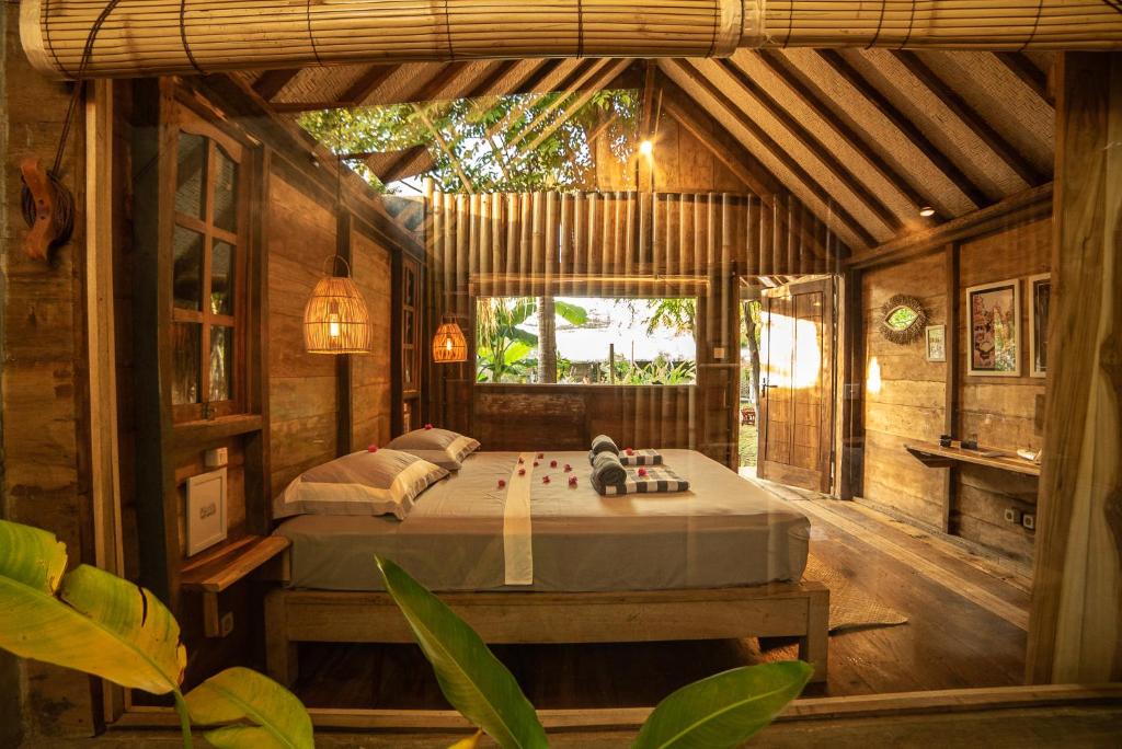 吉利阿尔Musa Villas and Bungalows Gili Air的木屋内的卧室配有一张床