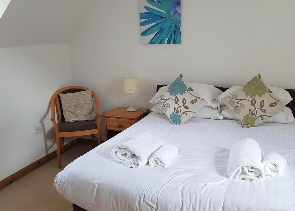 因弗戈登Heathfield Highland Estate的卧室配有白色床和毛巾