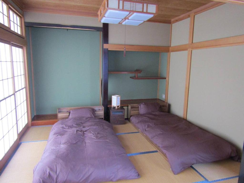 汤泽町Yuzawa Condo 一棟貸 貴重な駐車場2台無料的卧室位于客房的角落,配有两张床。
