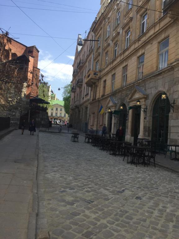 利沃夫Heart of Lviv的城市里一条鹅卵石街道,有桌子和建筑