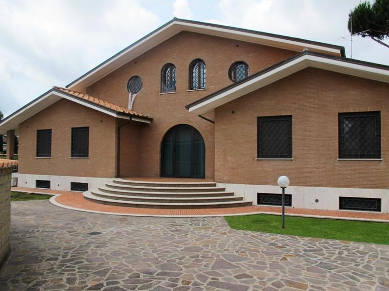 Infernetto斯美拉尔多罗马别墅酒店的一座带台阶和门的大型砖砌建筑