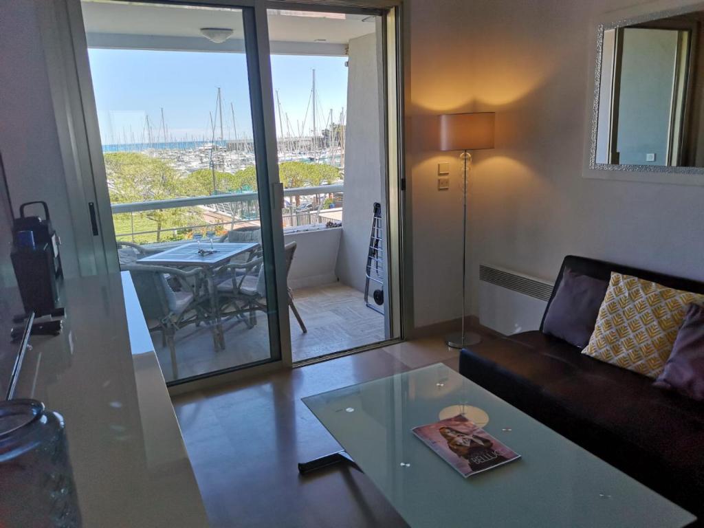 卢贝新城Ducal, Marina Baie des Anges的带沙发和桌子的客厅以及阳台。