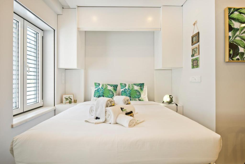 里斯本BmyGuest Bruno’s 36 Apartments的卧室配有带毛巾的大型白色床