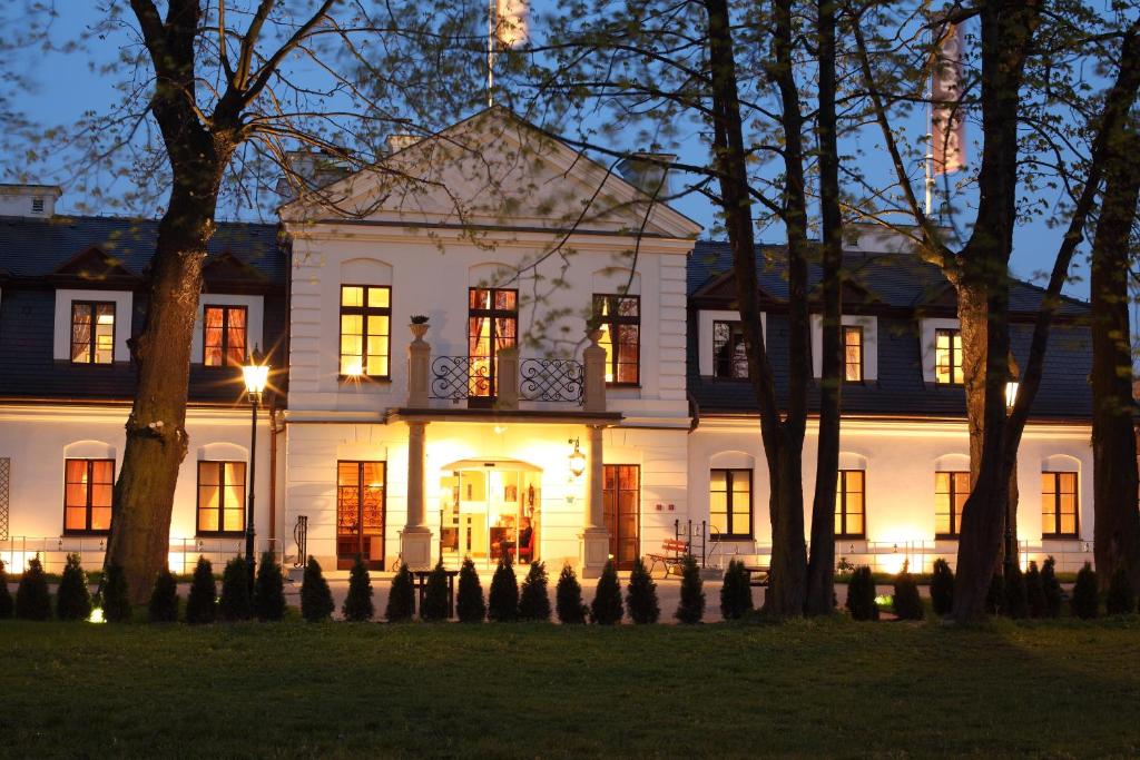 克拉科夫德沃科斯祖泽克酒店的一座白色的大房子,灯火通明