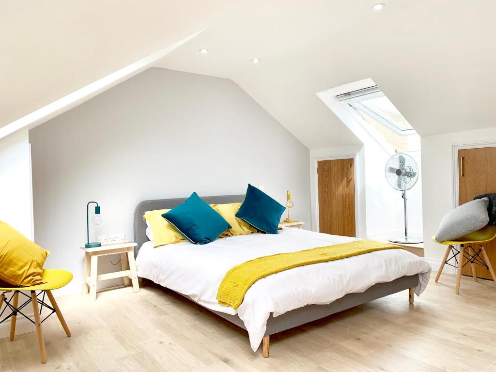 剑桥The Birches的一间卧室配有蓝色和黄色枕头的床