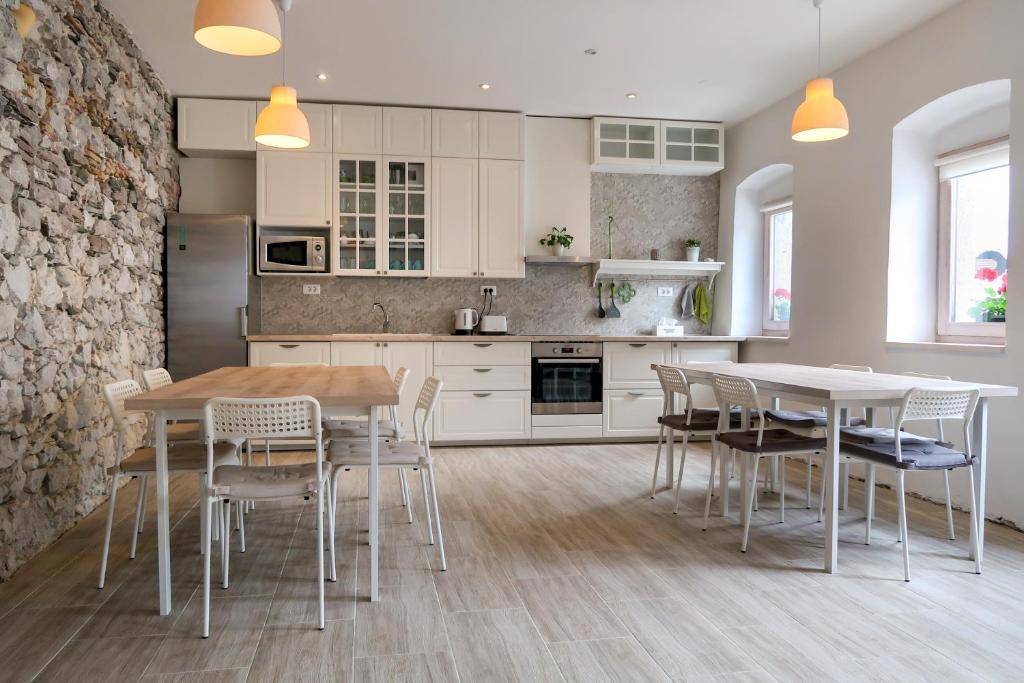科巴里德Premium Hostel Kobarid的一间带桌椅的厨房和一间带白色橱柜的厨房