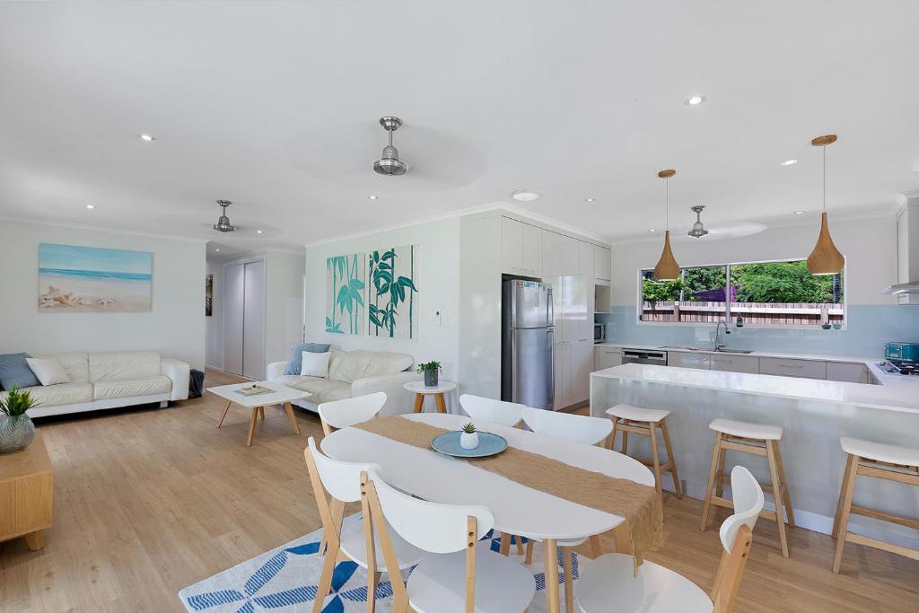 埃尔利海滩Whitsunday Palms by HamoRent的厨房以及带桌椅的起居室。