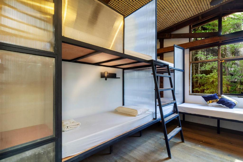 宿务The Flying Fish Hostel Cebu的带两张双层床和两扇窗户的房间