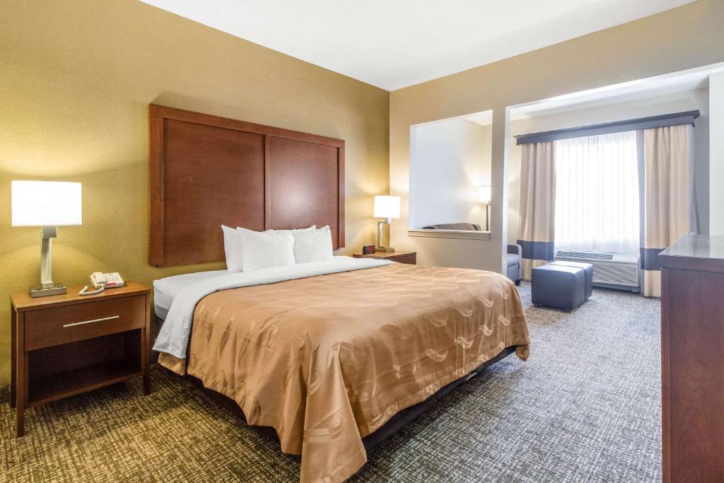 科尔宾Quality Suites的酒店客房设有一张床和一个大窗户