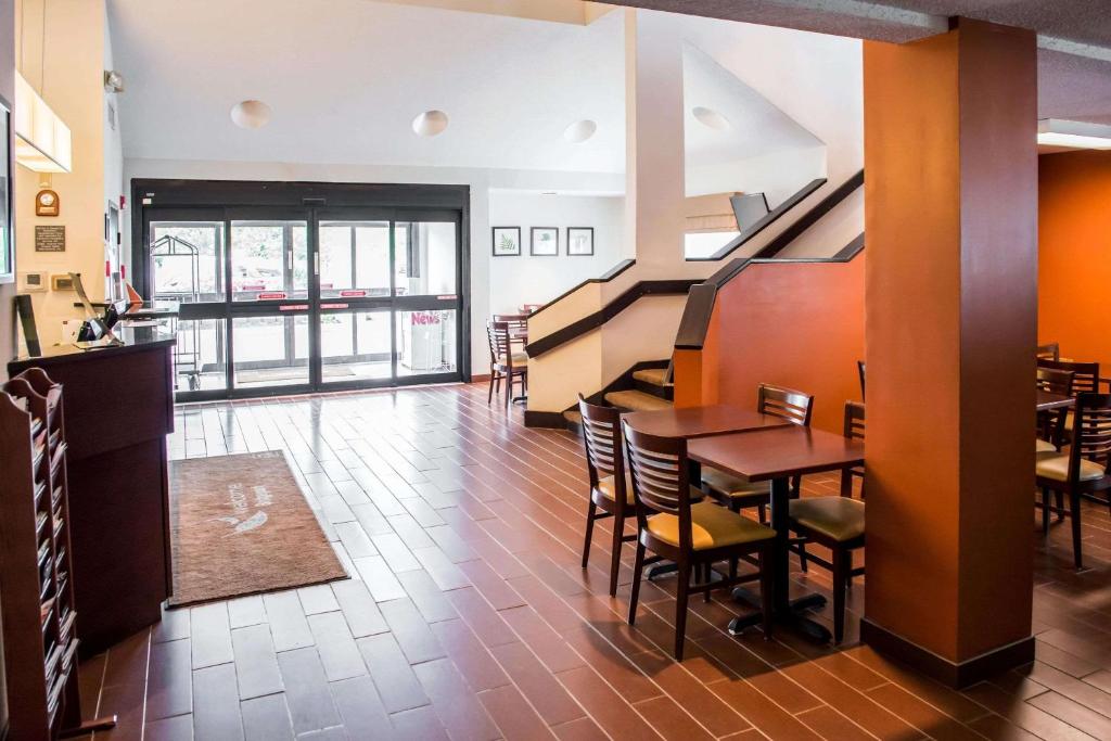 布里奇波特Quality Inn Bridgeport-Clarksburg的一间带桌椅和楼梯的餐厅