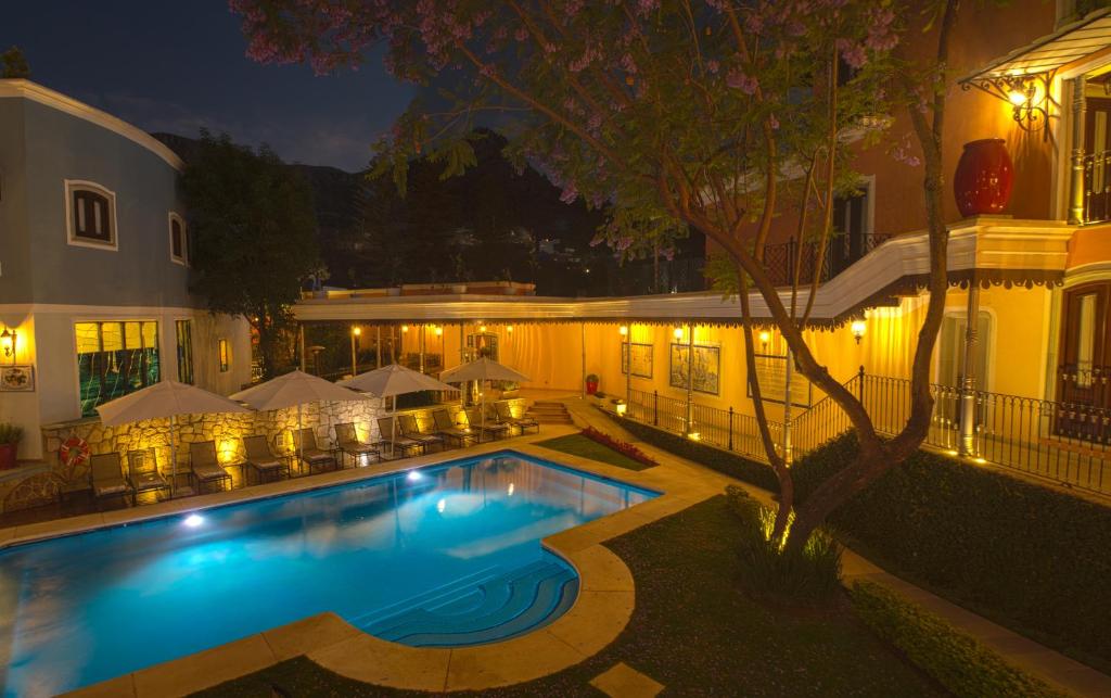 瓜纳华托玛丽亚克里斯蒂娜别墅酒店的一座游泳池,在晚上在建筑物前