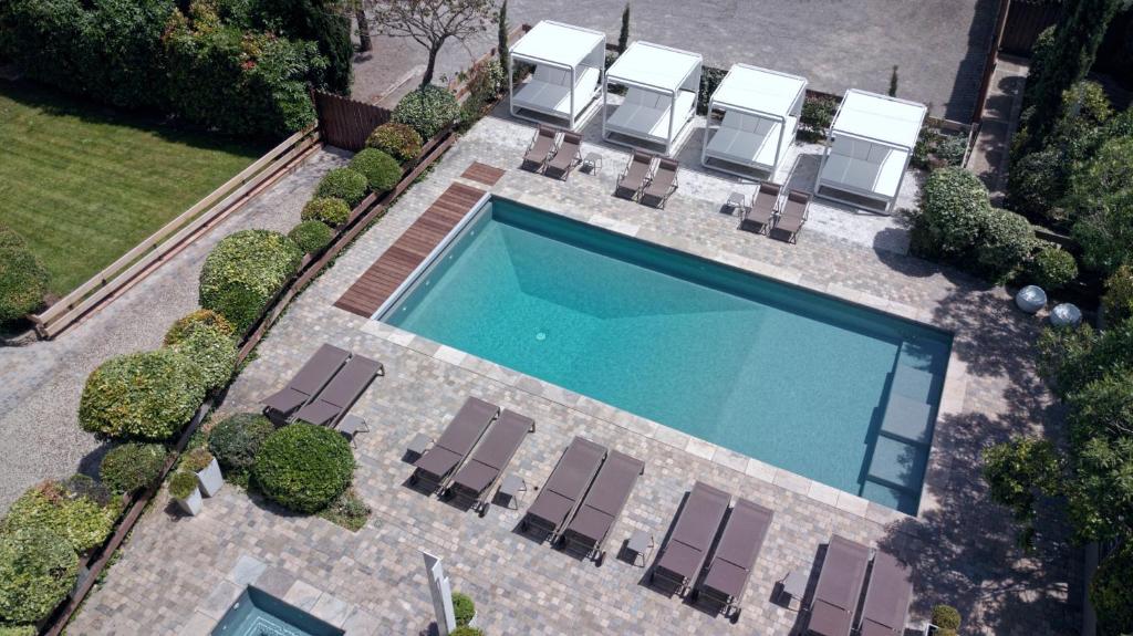 卡尔卡松Hôtel Montmorency & Spa的享有带躺椅和四柱戏池的游泳池的顶部景致。