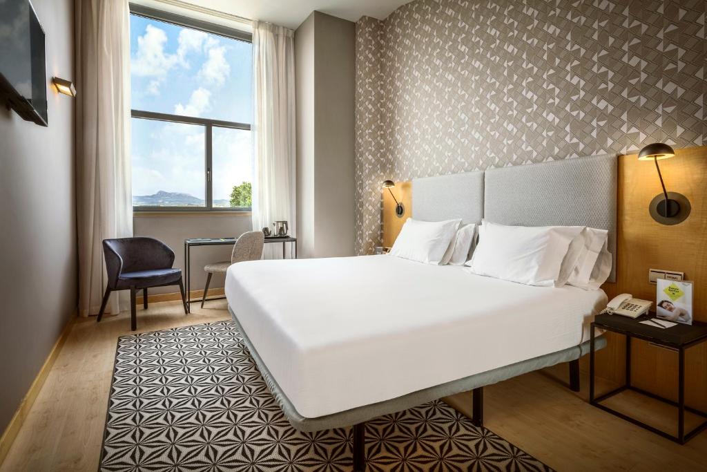 洛格罗尼奥塞尔科蒂尔波塔莱斯酒店的酒店客房设有一张白色大床和一张书桌