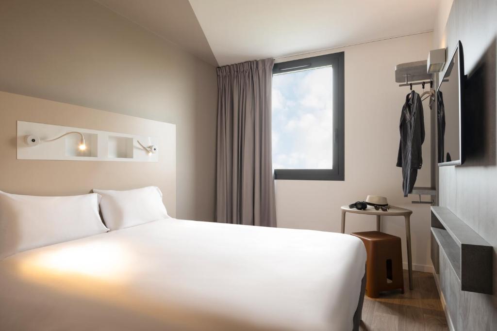 戈内斯ibis budget Gonesse的酒店客房设有白色的床和窗户。