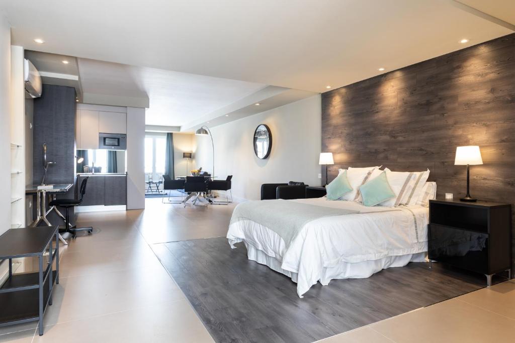 阿雷西费Rooms & Suites Loft 2E Deluxe Edition Arrecife的一间卧室设有一张带木墙的大床