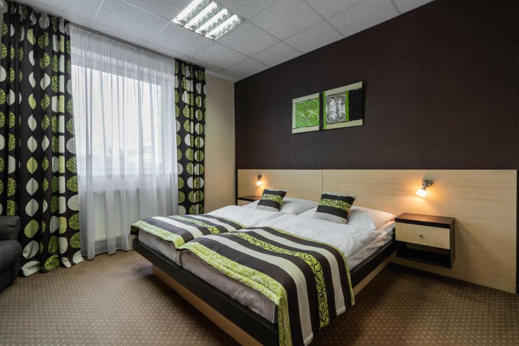 布拉迪斯拉发BNC酒店 - 餐厅 - 保龄球的一间卧室设有一张大床和一个窗户。