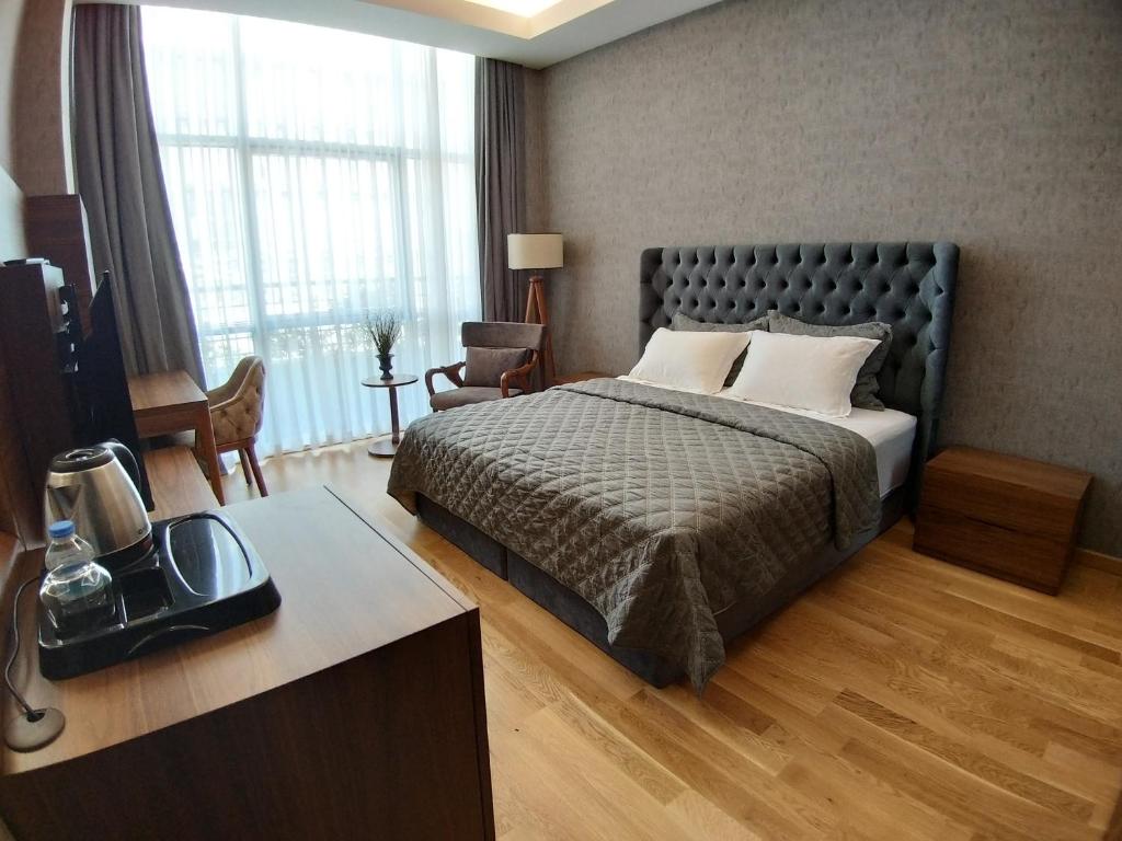 伊斯坦布尔Teknosports Otel的一间卧室配有一张床和一张书桌及电视