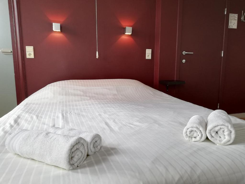 德帕内罗吉斯海特马安特杰酒店的一张床上有三条滚毛巾