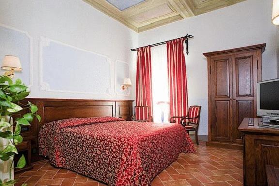 佛罗伦萨加州酒店的一间卧室配有一张红色床罩的床