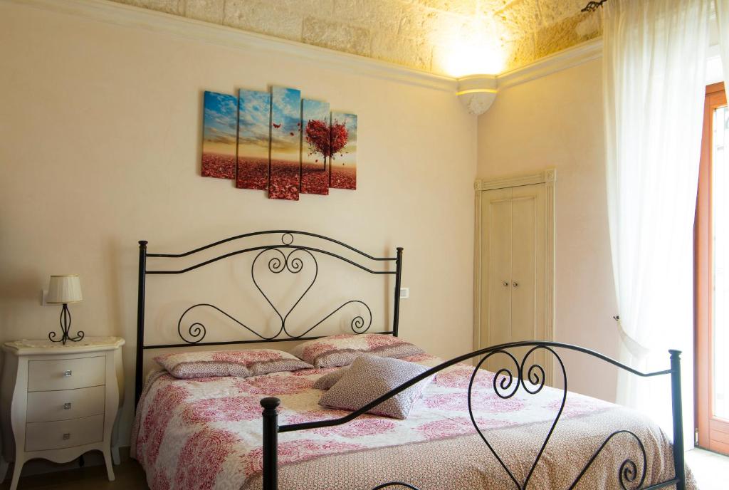 滨海波利尼亚诺Cà di Rò的卧室配有一张床,墙上挂有绘画作品