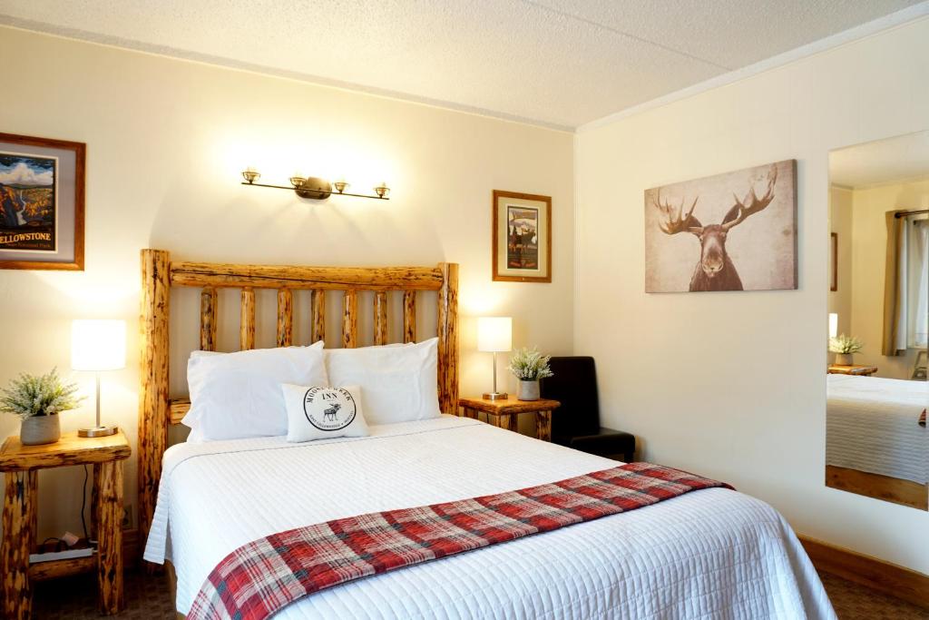 西黄石穆斯河客栈酒店的一间卧室配有一张带白色床罩的床