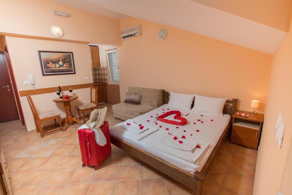 布德瓦Adzic Apartments的一间卧室配有一张带红色手提箱的床