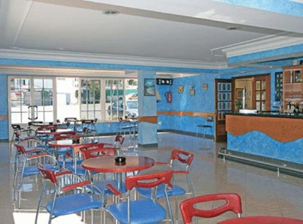 阿兰扎达哔波酒店的餐厅设有红色的桌椅和蓝色的墙壁