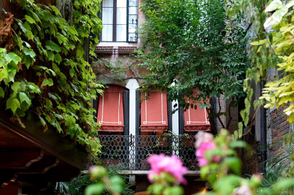 威尼斯弗洛拉酒店的一座有红色门的建筑,它常有常春藤
