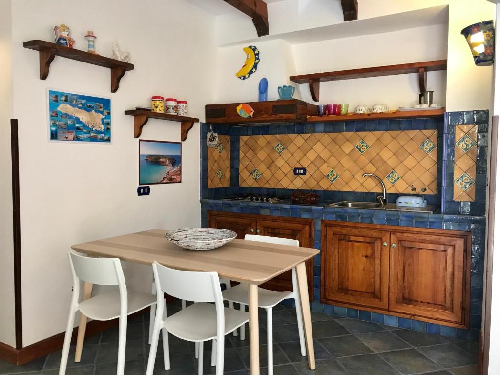 兰佩杜萨Le case di Nunzia的厨房配有木桌和白色椅子