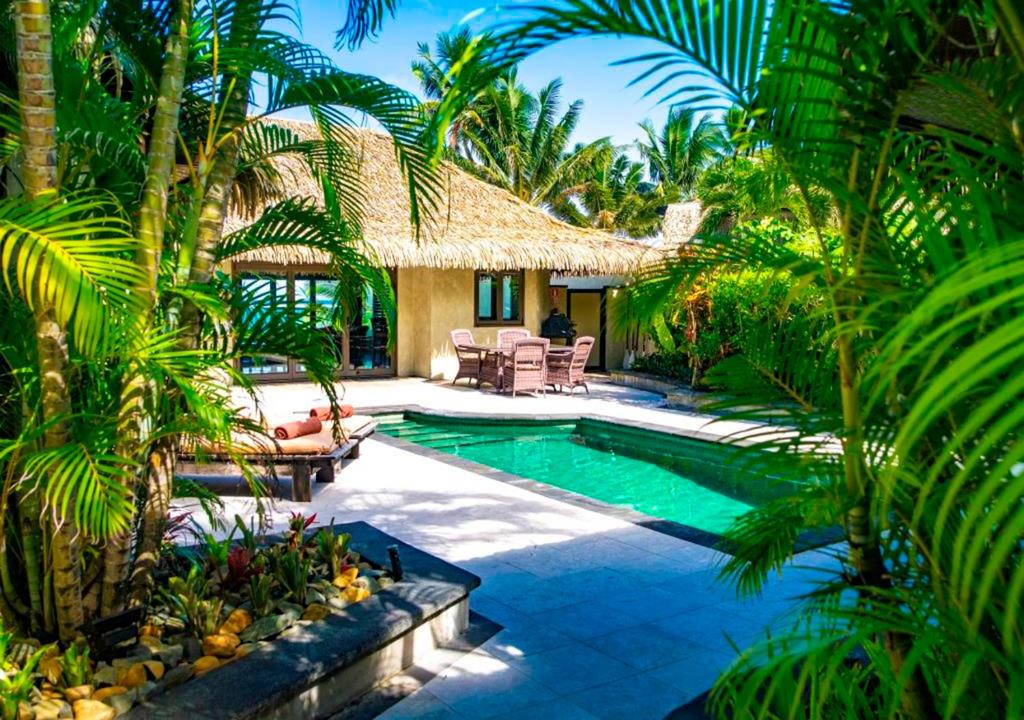拉罗汤加特摩纳豪华别墅及spa中心的棕榈树度假村内的游泳池